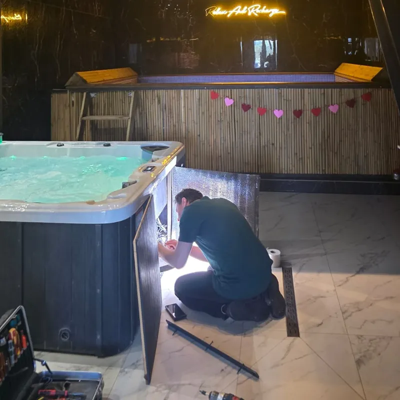 Monteur werkt aan de techniek achter het zijpaneel van een jacuzzi